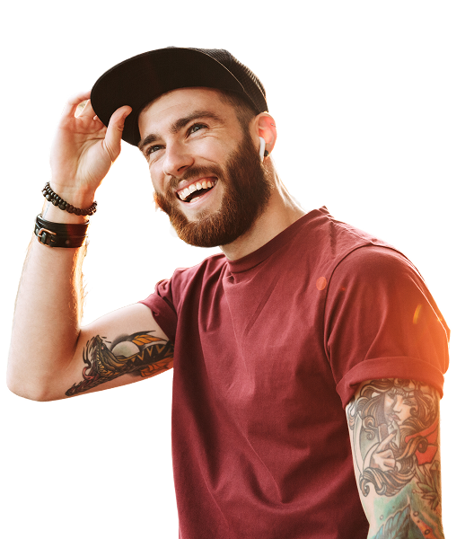 A man in a red t-shirt and a baseball cap smiles while looking up