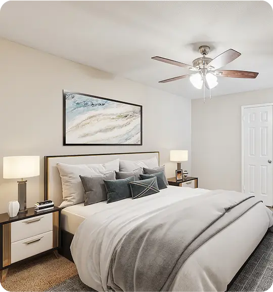 A bedroom with a ceiling fan and a picture above the headboard