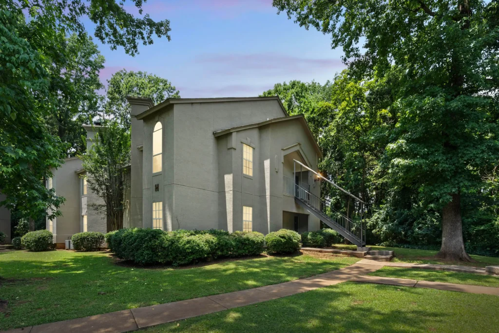 A white apartment building with lights in the windows